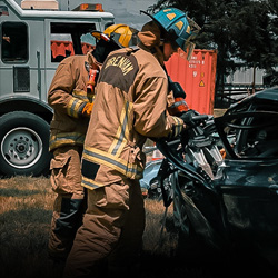 firefighters using a spreading tool on a vehicle