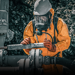 person in a hazmat suit holding a level